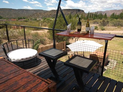 a deck with a table and two chairs and a picnic table at Balcon al Valle Grande, San Rafael Mendoza in Valle Grande