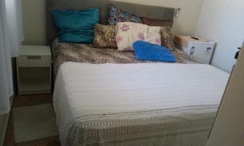 una cama pequeña con almohadas encima en Paraiso de Maracajaú 1, en Maracajaú