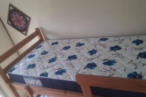 a bed with blue flowers on it in a room at N8 Casa 2 Dorm Zona Residencial Barrio Villa Lola Artigas in Artigas