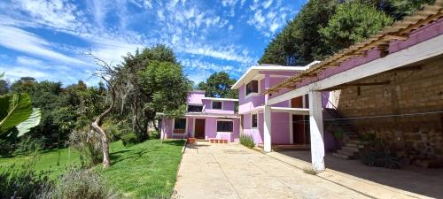una casa rosa con un sentiero di fronte di Hotel Bosques a Zacatlán