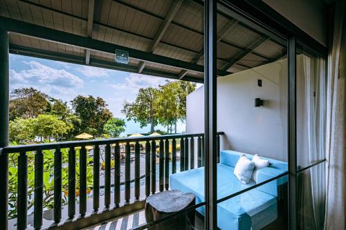 a room with a balcony with a blue couch at The ShellSea Krabi I Luxury Beach Front Resort & Pool Villa in Ao Nam Mao