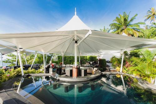 a large white umbrella over a swimming pool at The ShellSea Krabi I Luxury Beach Front Resort & Pool Villa in Ao Nam Mao