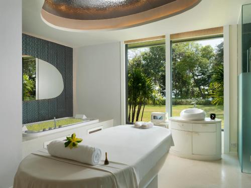 a white bedroom with a large bed and a large window at The ShellSea Krabi I Luxury Beach Front Resort & Pool Villa in Ao Nam Mao