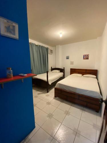 1 dormitorio con 2 camas y pared azul en Beautiful apartment near Malecon and Murcielago beach!, en Manta