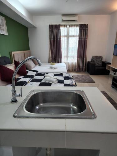 a kitchen with a sink in front of a bed at The Viana Apartment 3 in Kota Bharu
