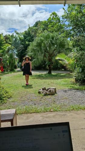 a woman in a hat walking in a park at Cabinas carol in Pavones