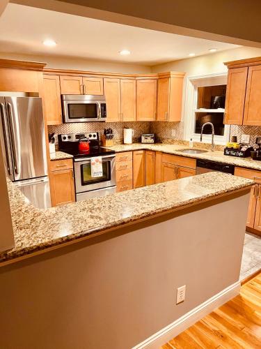 a kitchen with wooden cabinets and stainless steel appliances at Cedar Mill Hideaway in Woodbury