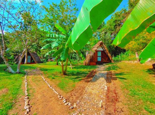 a dirt road in front of a small hut at Hotel Jasayma dentro del Parque Tayrona in El Zaino