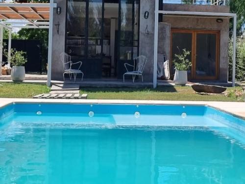 una piscina azul frente a una casa en Casa Arbet - Villa 25 de Mayo, San Rafael, Mendoza, en San Rafael