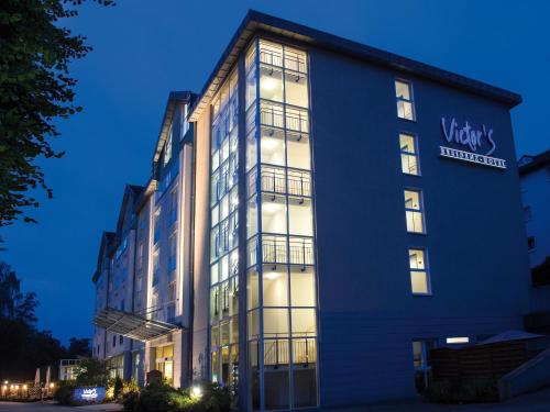 un edificio alto azul con un letrero. en Victor's Residenz-Hotel Gummersbach, en Gummersbach