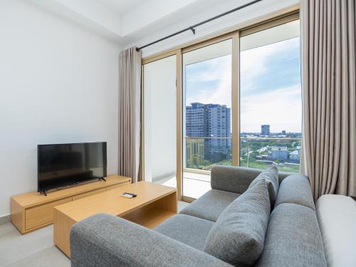 a living room with a couch and a large window at 85 SOHO Hotel & Apartment in Phnom Penh