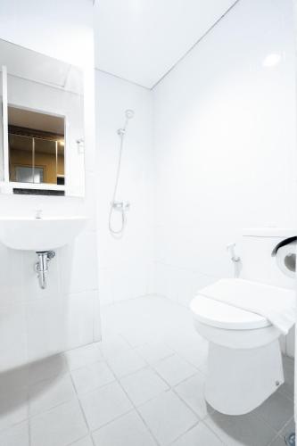 a white bathroom with a toilet and a sink at One Living At Menara One in Solo
