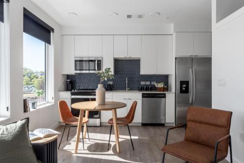 a kitchen with a table and chairs and a refrigerator at Mint House Nashville - The Gulch - Division St in Nashville