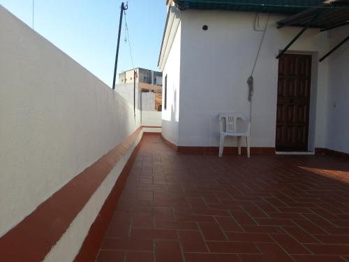 a white chair sitting on the side of a building at Hostal Trajano in Seville