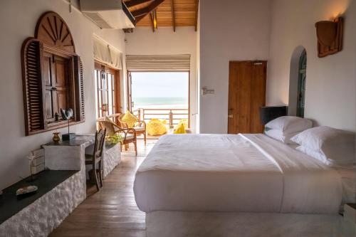 a bedroom with a bed and a view of the ocean at Sānti Beach House with pool & beach in Weligama