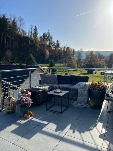 a patio with a couch and a table on a roof at Apartmany pod Pustevnami in Prostřední Bečva