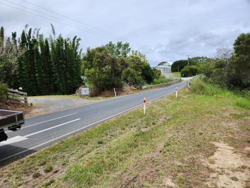 an empty road with a truck driving down it at Whalers retreat in Pukenui