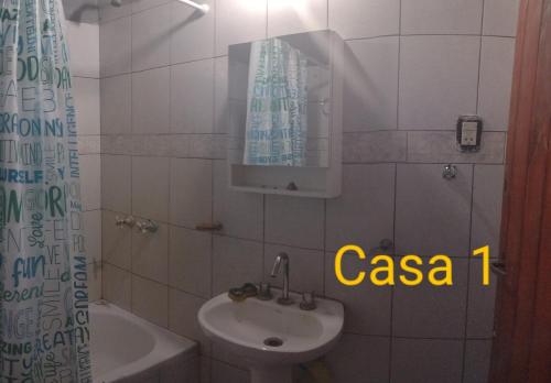 uma casa de banho com um lavatório, um WC e um espelho. em El descanso em Santa Teresita