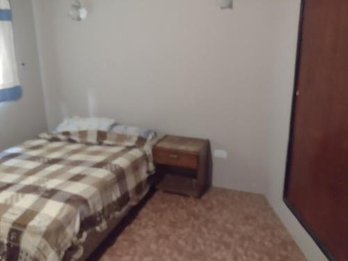 Dormitorio pequeño con cama y mesa en El descanso en Santa Teresita