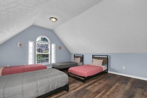 1 dormitorio con 2 camas y ventana en Spacious & Modern Home with everything you need!, en Westerville
