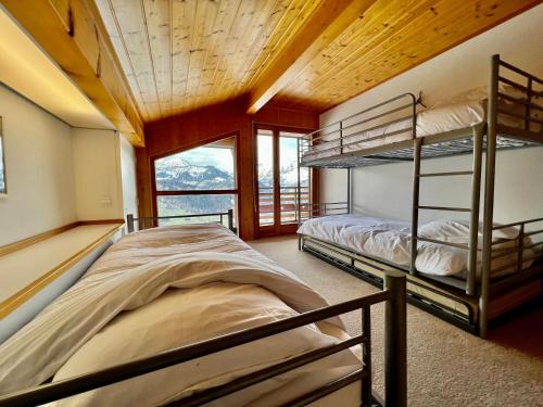two bunk beds in a room with a window at Chalet Crest-Voland, 7 pièces, 8 personnes - FR-1-505-181 in Crest-Voland