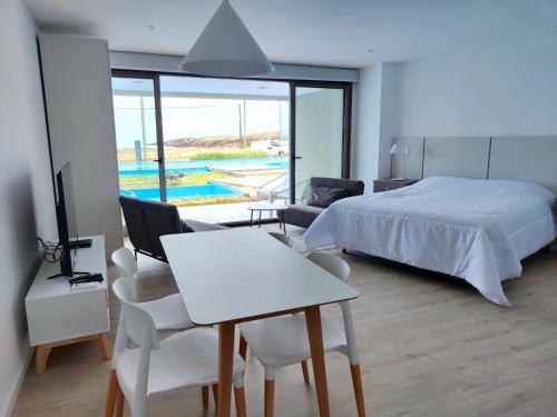 a bedroom with a bed and a table and chairs at SYRAH Premium B2 - Piscina privada con vista al mar by depptö in Punta del Este