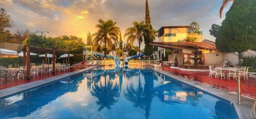 een zwembad in een resort met een glijbaan bij Hotel y Restaurant Puesta del Sol in Ocotlán