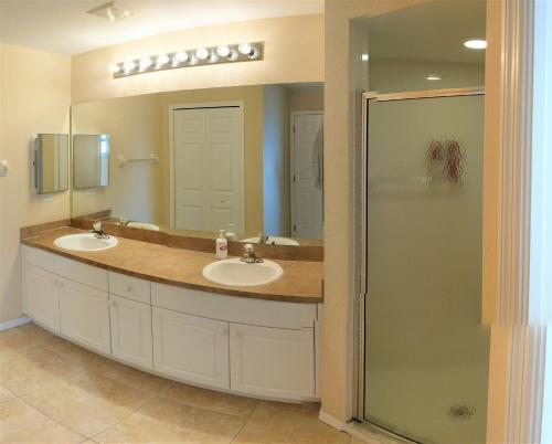 a bathroom with two sinks and a shower at Villa Luhna 3 Bed / 2 Bath Canalfront Heated Pool in Cape Coral