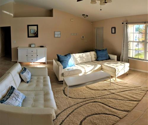 a living room with two white couches and a rug at Villa Luhna 3 Bed / 2 Bath Canalfront Heated Pool in Cape Coral