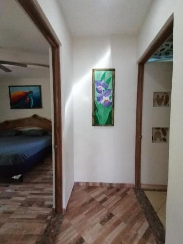 a room with a bed and a painting on the wall at Garza Tigre Apartamentos in Cóbano