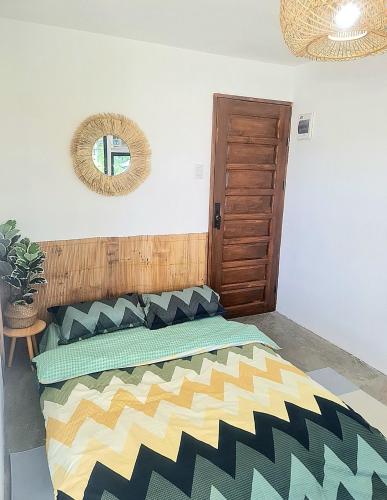 Schlafzimmer mit einem Bett und einem Wandspiegel in der Unterkunft Dolores Residences Rm Bianca in General Santos
