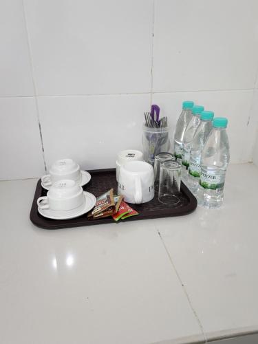 ein Tablett mit Geschirr und Wasserflaschen auf der Theke in der Unterkunft The Viana Apartment V in Kota Bharu