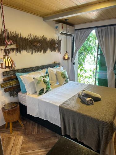 1 dormitorio con 1 cama grande y mesa en Casa aluguel ilha grande,Mar 2 en Ilha Grande