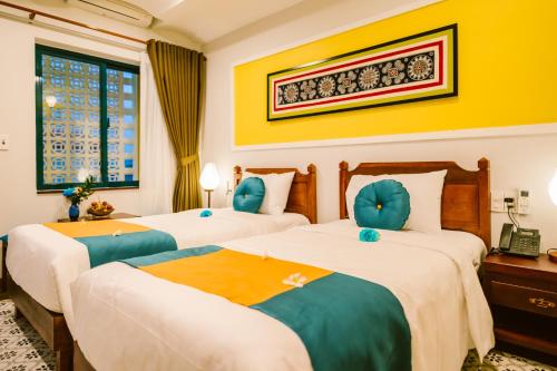 Postel nebo postele na pokoji v ubytování De'Colore Villa Hoi An