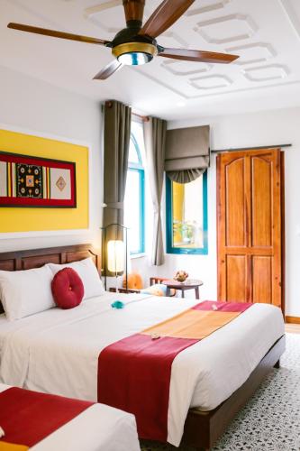 Postel nebo postele na pokoji v ubytování De'Colore Villa Hoi An