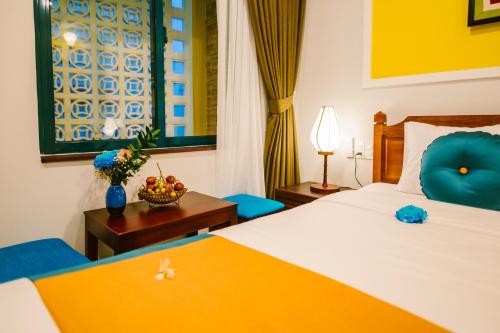 Postel nebo postele na pokoji v ubytování De'Colore Villa Hoi An
