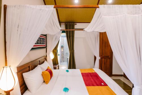 Postel nebo postele na pokoji v ubytování De'Colore Villa Hoi An