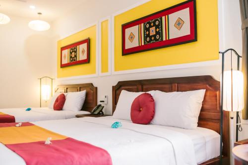 Postel nebo postele na pokoji v ubytování De'Colore Villa Hoi An