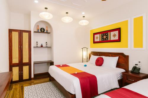 Postel nebo postele na pokoji v ubytování De'Colore Villa Hoi An