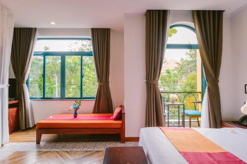 Postel nebo postele na pokoji v ubytování De'Colore Villa Hoi An
