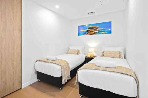 a bedroom with two beds and a painting on the wall at Casino residence 2-BR ocean view in Gold Coast