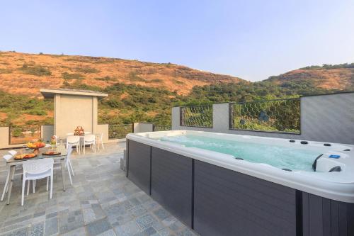 a large bath tub sitting on top of a patio at StayVista's Le Sutra Great Escapes - Udaan - Artistic Rooms, Terrace Jacuzzi with Scenic View in Lonavala