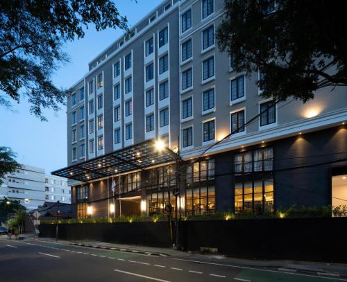 Maia Hotel Jakarta في جاكرتا: مبنى كبير على شارع المدينة ليلا