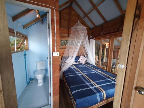 a bedroom with a bed with a mosquito net at Palm Beach Resort Koh Phayam in Ko Phayam