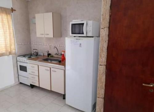 una cucina con frigorifero bianco e forno a microonde di Duplex a Santa Teresita