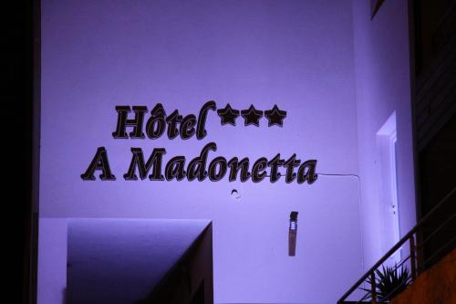 a wall with a sign that readsoved a madonnazona at Hôtel A Madonetta in Bonifacio