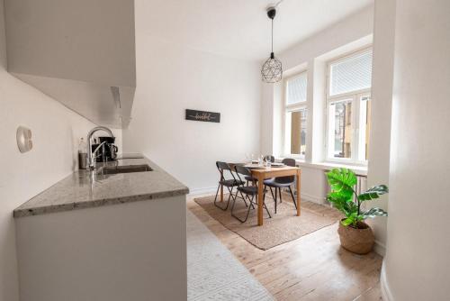 a kitchen and dining room with a table and chairs at 2ndhomes Mikonkatu Apartment 4 in Helsinki
