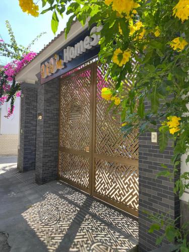 a large wooden gate to a building with flowers at VIVU HOMESTAY VUNG TAU in Vung Tau