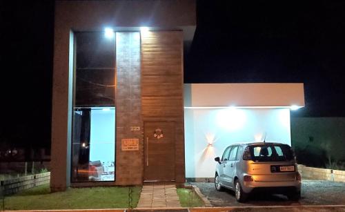 a small car parked in front of a building at night at BALNEÁRIO GAIVOTA no AREIAS CLARAS in Sombrio