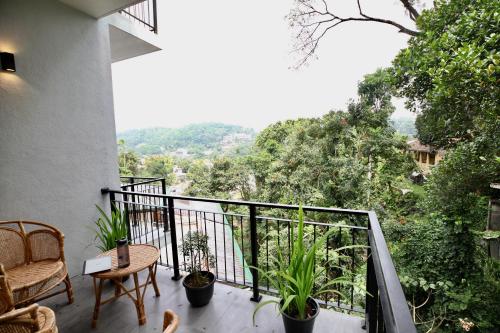 a balcony with a table and chairs and a view at Hidden relaxation at Kings residence in Kandy